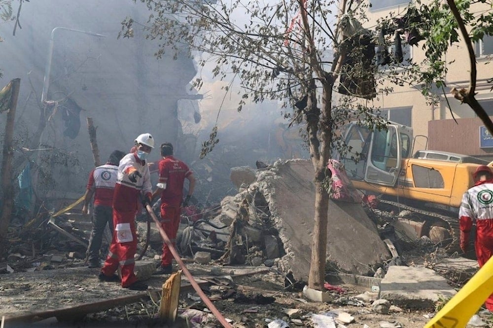 In this photo released by the Iranian Red Crescent Society rescuers work at the scene of an explosion after an Israeli strike in Tehran, Iran, Friday, June 13, 2025. (AP)