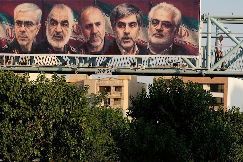 A man walks past a billboard displaying images of top Iranian commanders and scientists killed in Israeli strikes early Friday, in Tehran, Iran, Friday, June 13, 2025 (AP)