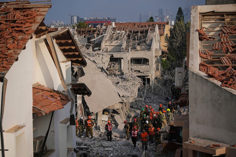 Israeli security forces inspect destroyed houses that were struck by a missile fired from Iran, in Rishon Lezion, occupied Palestine on June 14, 2025. (AP Photo/Ohad Zwigenberg)