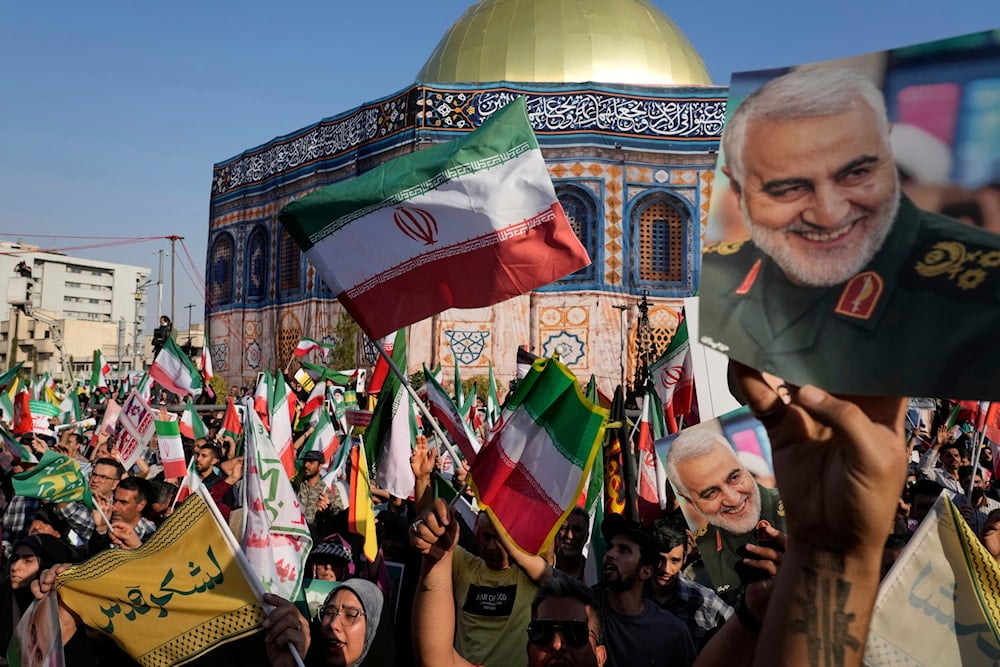 Protesters wave Iranian flags and hold images of late General Qassem Soleimani near a model of Jerusalem's Dome of the Rock during an Eid al-Ghadir rally in Tehran, June 14, 2025. (AP)