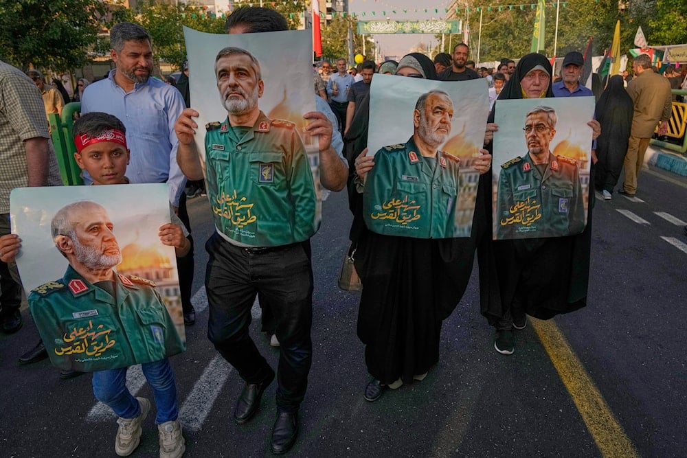 Demonstrators carry posters of top Iranian commanders killed in Friday's Israeli strikes, Tehran, Iran, Saturday, June 14, 2025 (AP)