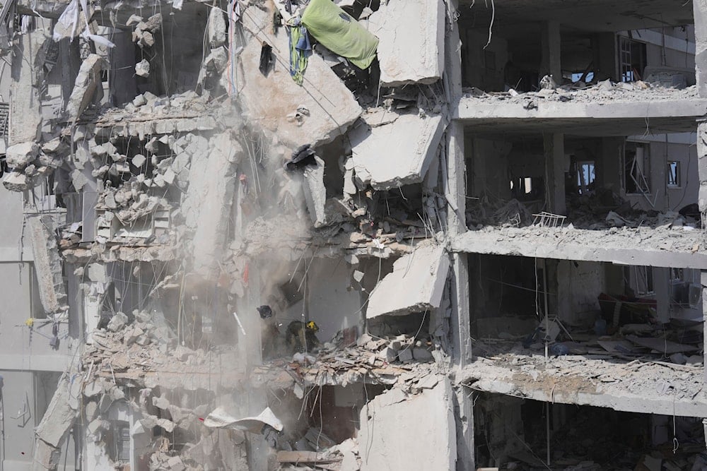 Concrete and rubble fall from a heavily damaged building as Israeli soldiers search for survivors in a residential area hit by a missile fired from Iran, near Tel Aviv, Israel, Sunday, June 15, 2025 (AP)
