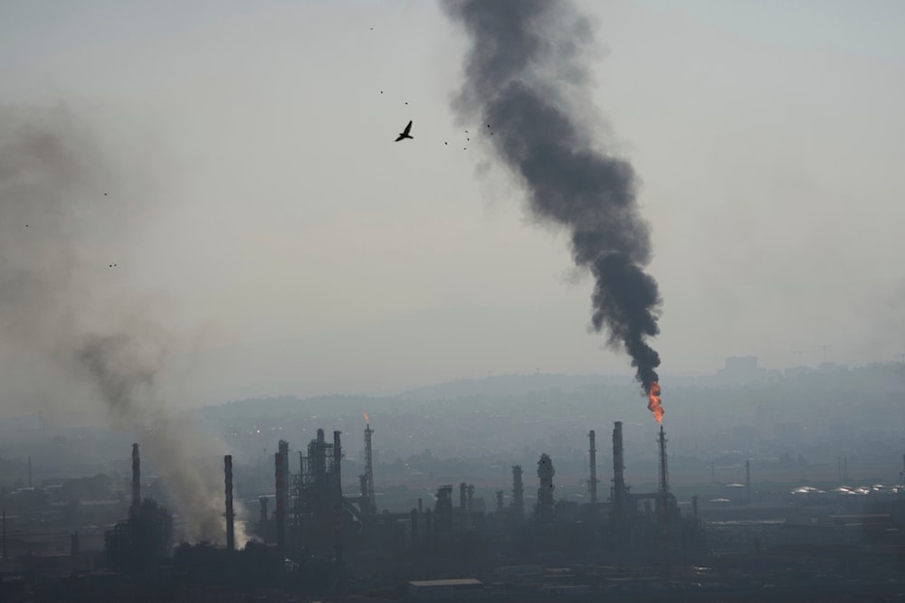 Smoke billows after an Iranian missile struck an oil refinery in Haifa, northern occupied Palestine, early Monday, June 16, 2025 (AP)