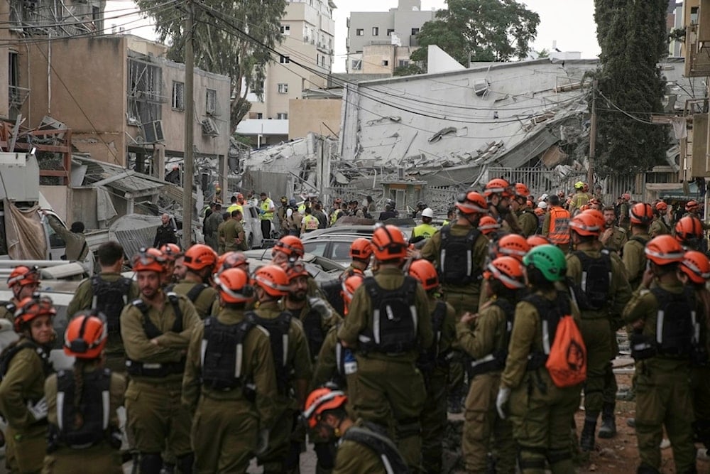 Rescue workers, police, and military inspect the site where an Iranian missile struck in Bnei Brak, near Tel Aviv, occupied Palestine, Monday, June 16, 2025 (AP)