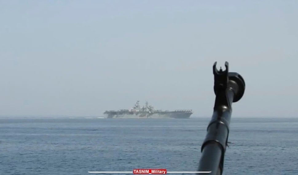 In this image provided by the Iranian Revolutionary Guard via Tasnim News Agency on Sunday, Aug. 20, 2023, a machine gun's muzzle of a Revolutionary Guard speedboat is seen as the boat moves near USS Bataan at the Strait of Hormuz. (AP)