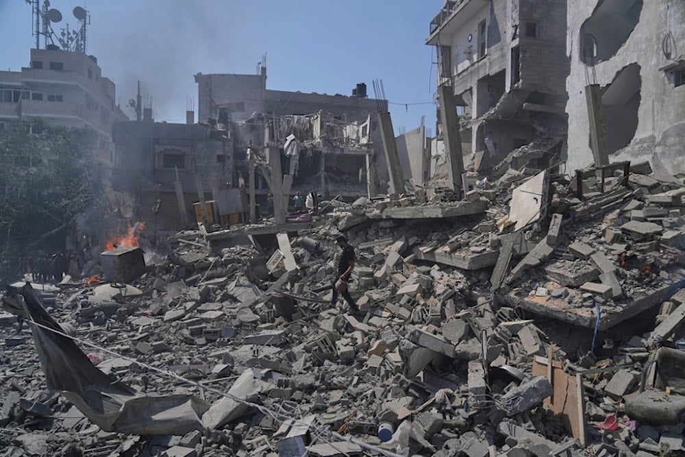 A Palestinian man walks across the rubble of a building destroyed by an Israeli strike in Deir al-Balah, central Gaza Strip, Monday, June 16, 2025. (AP Photo/Abdel Kareem Hana)
