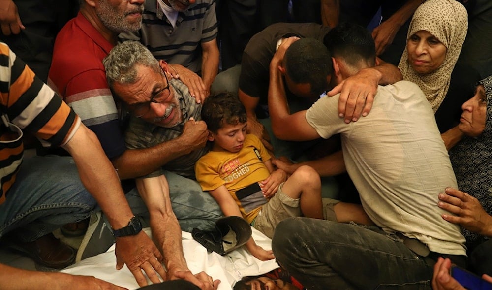 Ata Qasas, center left, mourns over the body of his son Rashad Qasas, who was killed while heading to an aid distribution hub, during his funeral in Rafah, southern Gaza Strip, Wednesday, June 11, 2025. (AP)