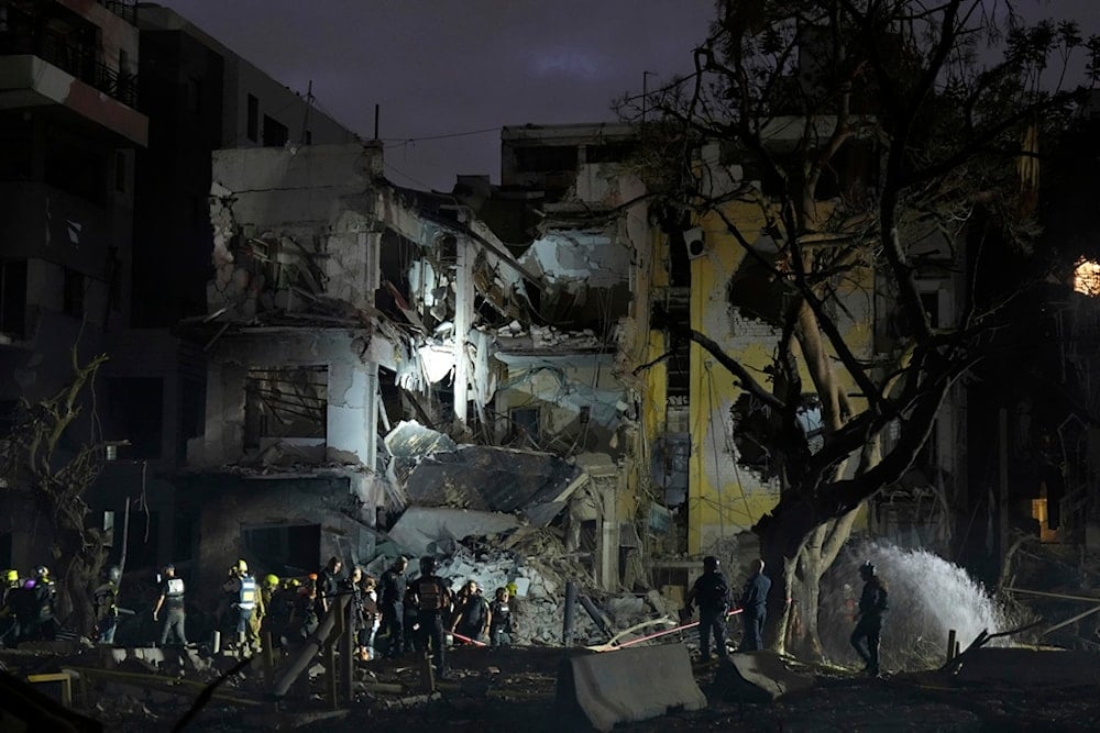 Rescue team work at the site where a missile launched from Iran struck Tel Aviv, occupied Palestine, Monday, June 16, 2025. (AP Photo/Baz Ratner)