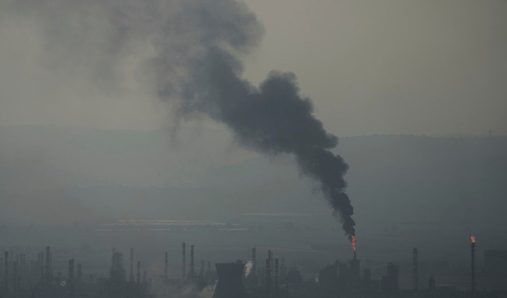 Smoke billows after an Iranian missile struck an oil refinery in Haifa, northern occupied Palestine, early Monday, June 16, 2025. (AP)