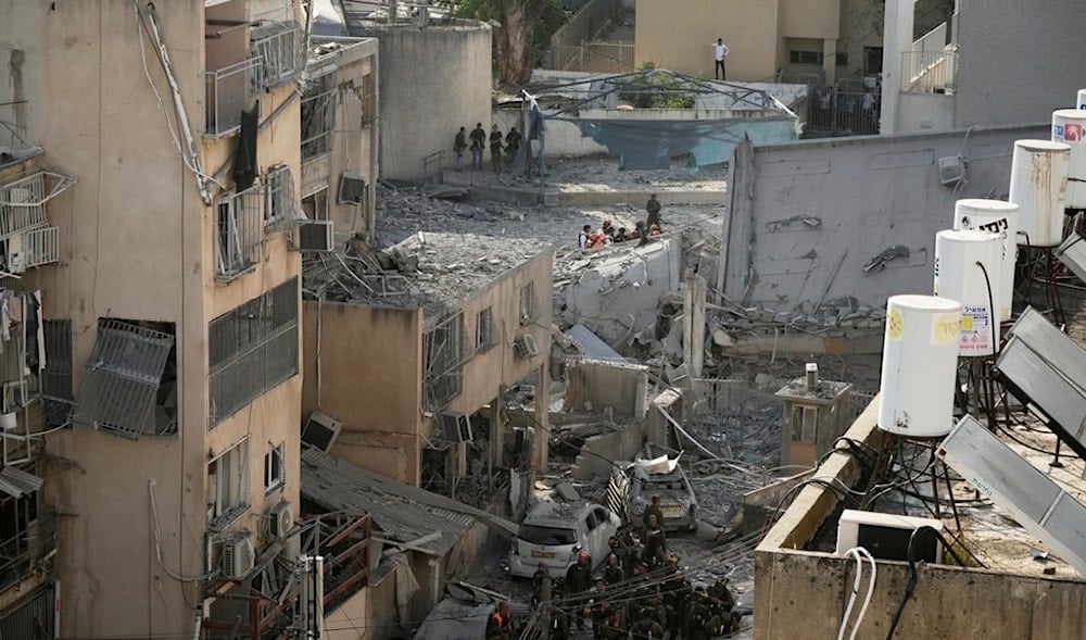 Rescue workers, police and military inspect the site where an Iranian missile struck in Bnei Brak, near Tel Aviv, Monday, June 16, 2025. (AP)