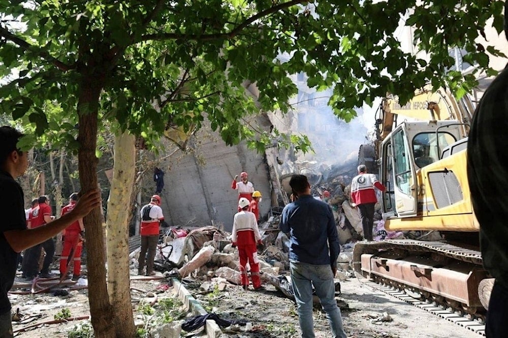 In this photo released by the Iranian Red Crescent Society rescuers work at the scene of an explosion after an Israeli strike in Tehran, Iran, Friday, June 13, 2025 (AP)