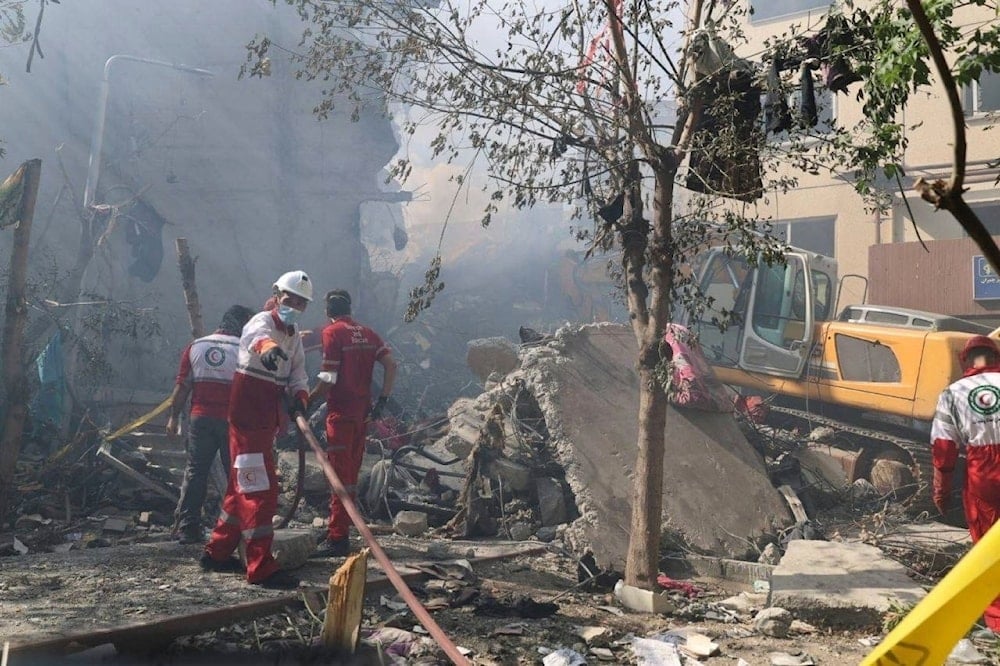 In this photo released by the Iranian Red Crescent Society rescuers work at the scene of an explosion after an Israeli strike in Tehran, Iran, Friday, June 13, 2025. (Iranian Red Crescent Society via AP)