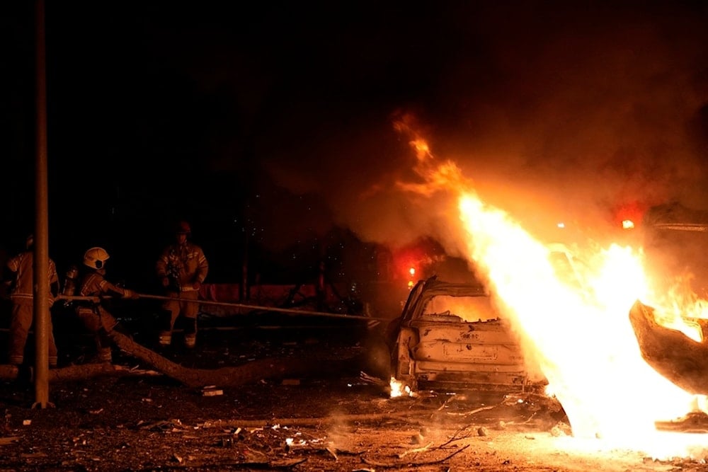 Firefighters work to extinguish a blaze after a missile launched from Iran struck Tel Aviv, occupied Palestine, Monday, June 16, 2025 (AP)