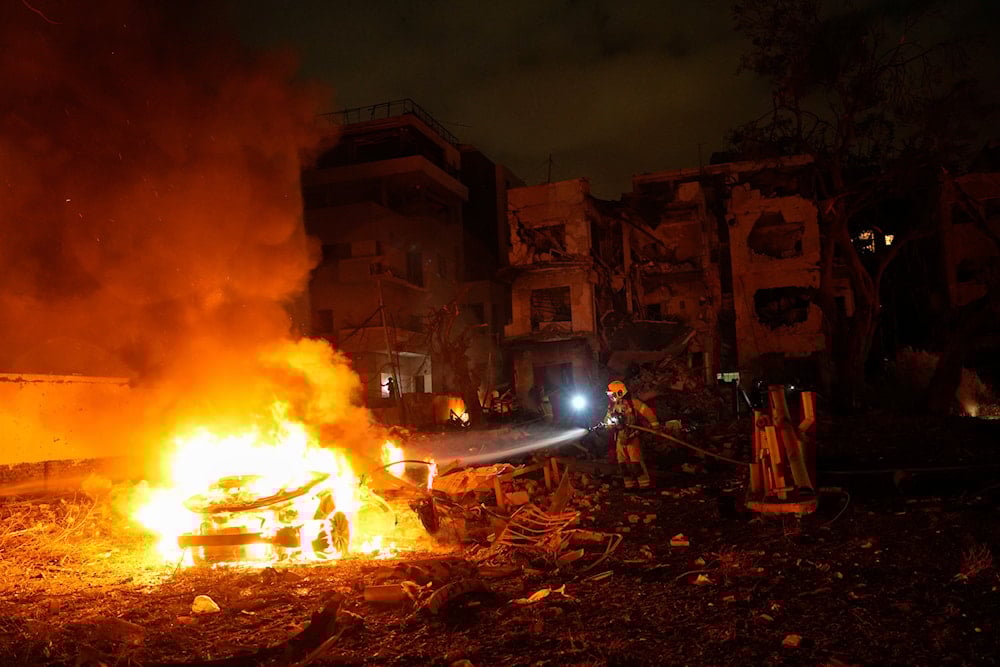 Firefighters work to extinguish a blaze after a missile launched from Iran struck Tel Aviv, occupied Palestine on June 16, 2025. (AP Photo/Baz Ratner)