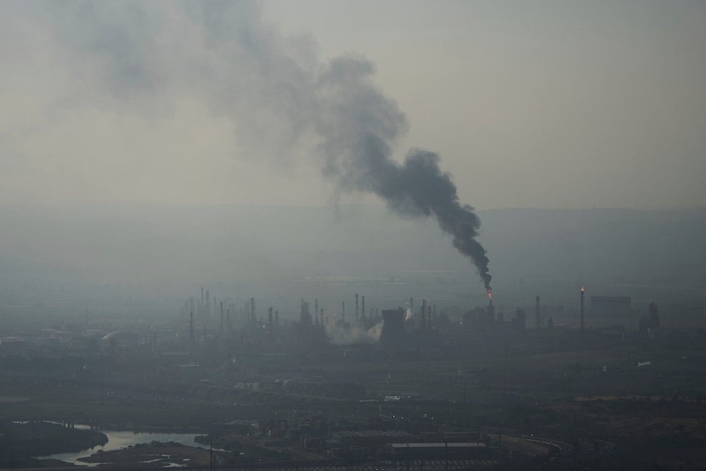 Smoke billows after an Iranian missile struck an oil refinery in Haifa, northern Israel, early Monday, June 16, 2025. (AP Photo/Ariel Schalit)