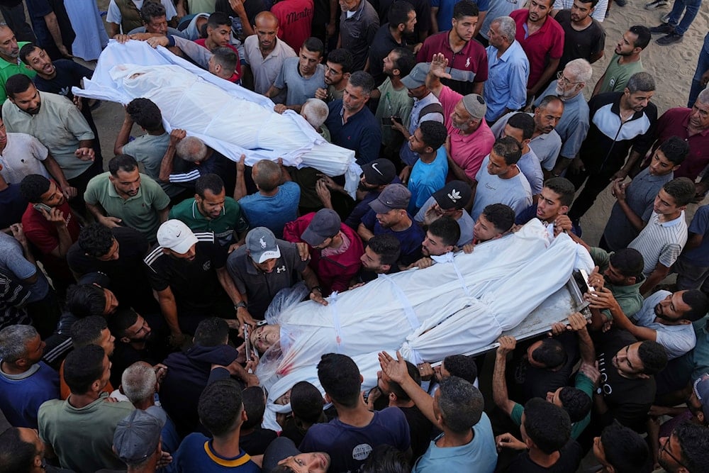 Palestinians carry the bodies of relatives who were killed in an Israeli military strike on Gaza, at Al-Shifa Hospital in Gaza City, Thursday, June 19, 2025 (AP)