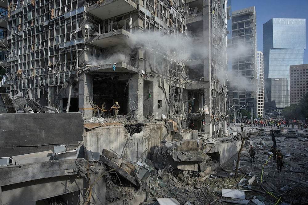 Rescue workers and military personnel inspect the site of a direct hit from an Iranian missile strike in Ramat Gan, Occupied Palestine, Thursday, June 19, 2025 (AP)