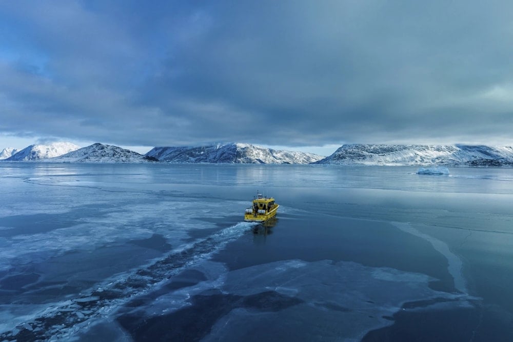 A boat rides though a frozen sea inlet outside of Nuuk, Greenland, March 6, 2025 (AP/Evgeniy Maloletka)