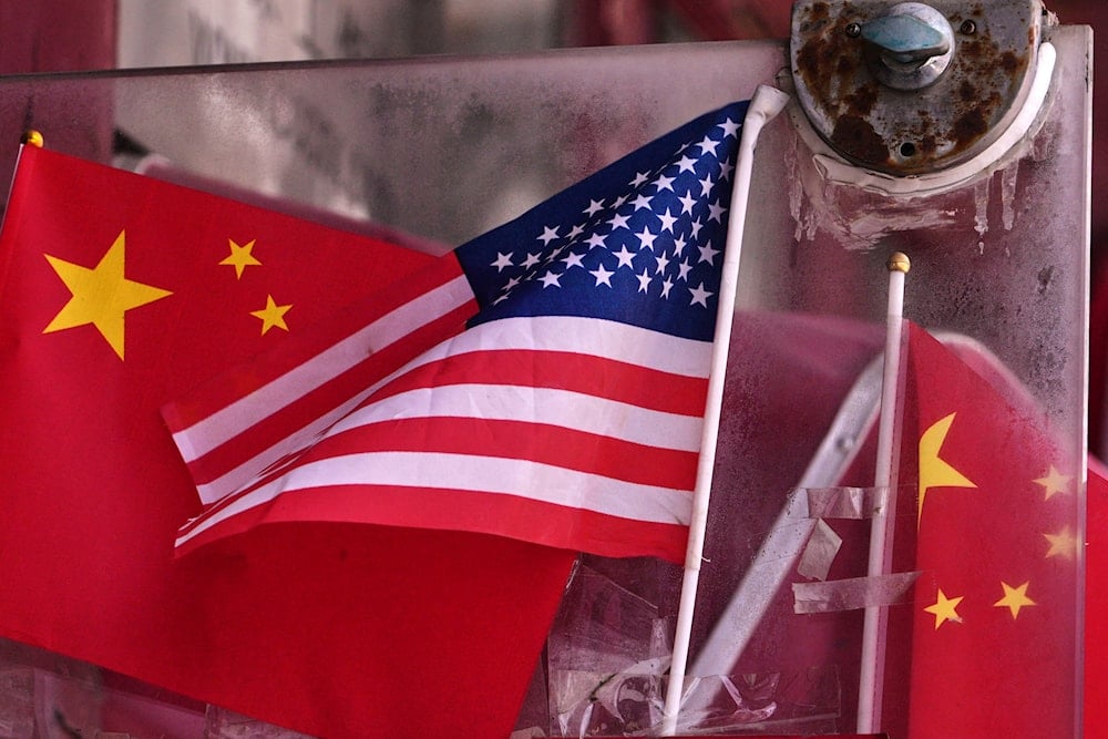 China and U.S. national flags are seen on display on an entrance door of a souvenir shop in Beijing on April 3, 2025 (AP)