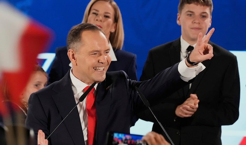Presidential candidate Karol Nawrocki greets supporters as he arrives at his headquarters after the presidential election runoff in Warsaw, Poland, Sunday, June 1, 2025. (AP)