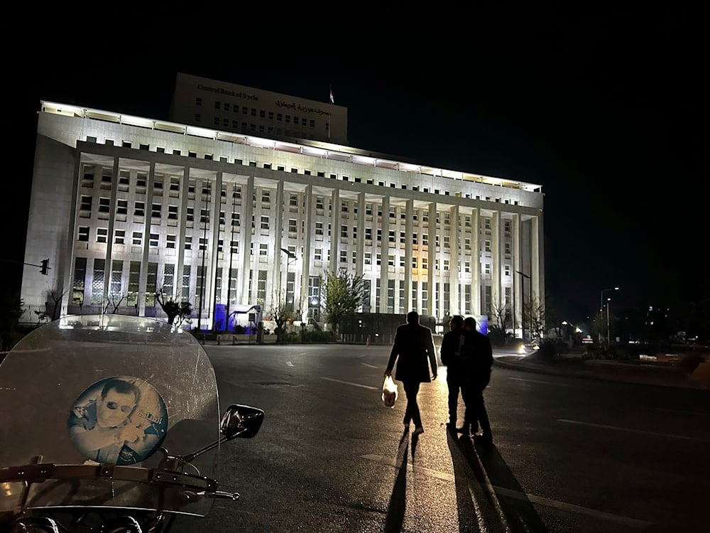 Syrian citizens walk in front the building of the Syrian Central Bank in Damascus, Syria, Saturday, Dec. 7, 2024 (AP)