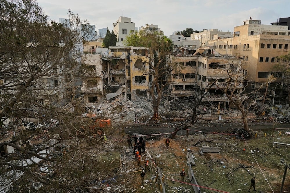 Rescue team work at the site where a missile launched from Iran struck Tel Aviv, occupied Palestine, Monday, June 16, 2025. (AP Photo/Baz Ratner)