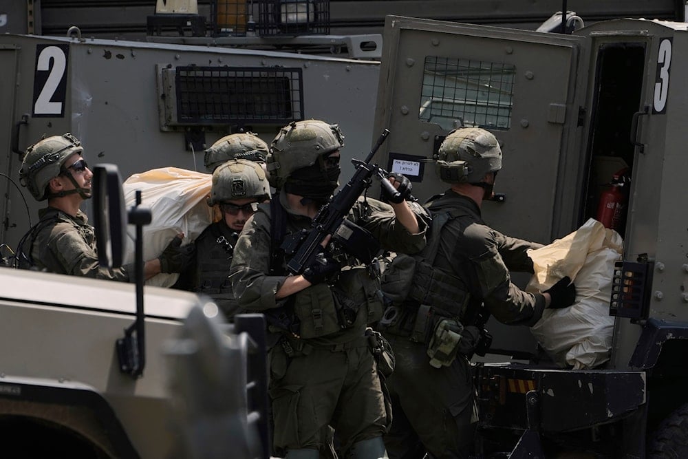 Israeli soldiers load bags into an armored vehicle during a military raid in the West Bank city of Nablus, Palestine Tuesday, June 10, 2025 (AP)