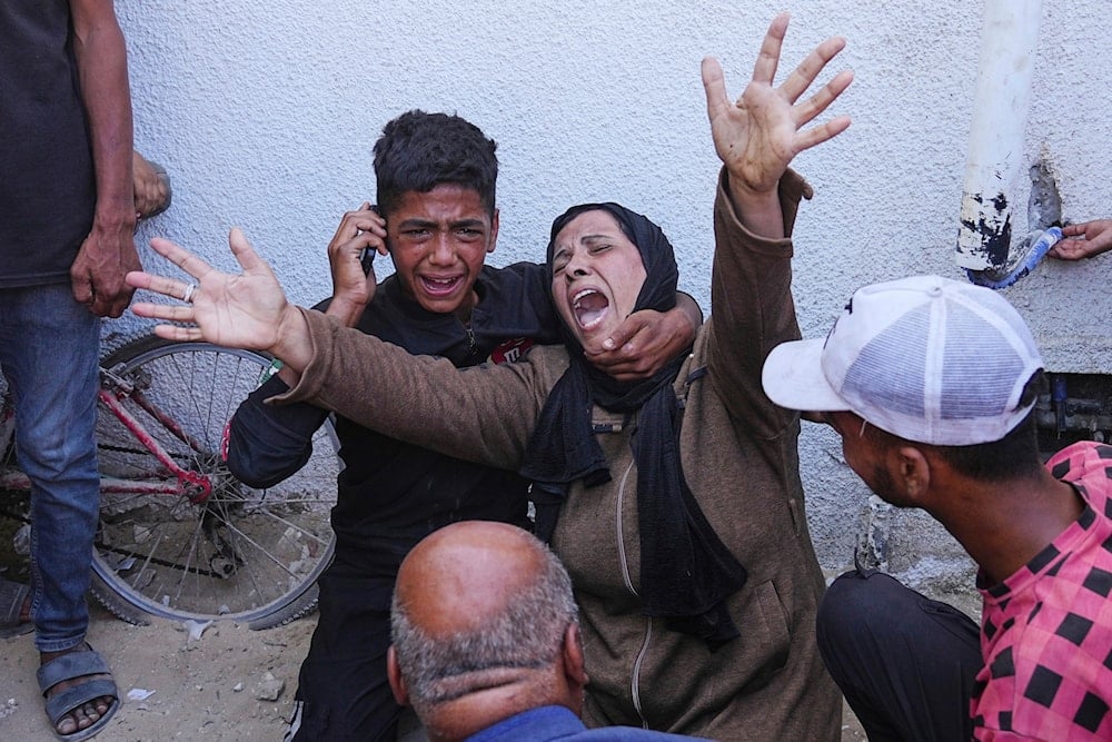 A Palestinian woman mourns over the body of her child killed in an Israeli military strike on Gaza, at Al-Shifa Hospital in Gaza City, Thursday, June 19, 2025 (AP)