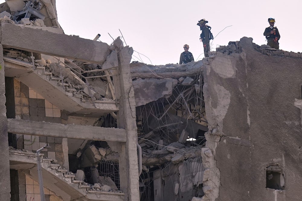 Israeli home front command units work in an unpopulated damaged building after it was hit by a missile fired from Iran, in Haifa, Israel, Friday, June 20, 2025 (AP)