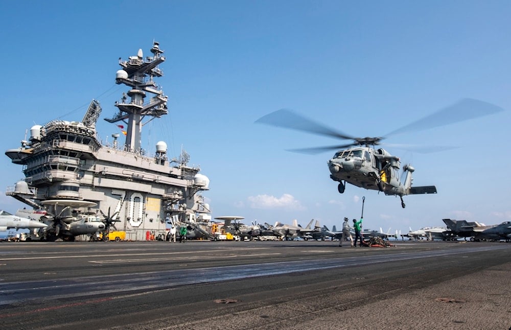 This photograph released by the US Navy shows an MH-60S Sea Hawk helicopter hovering over the USS Carl Vinson aircraft carrier while operating in the Middle East, April 12, 2025 (AP)