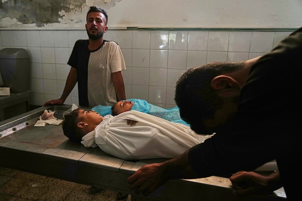 Palestinian father mourns over the bodies of children killed in an Israeli military strike on Gaza, at the morgue of Al-Shifa Hospital in Gaza City, Thursday, June 19, 2025. (AP)