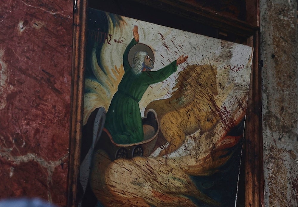 Blood stains a religious painting inside Mar Elias Church, where a suicide bomber detonated himself in al-Dwela, on the outskirts of Damascus, Syria, on Sunday, June 22, 2025 (AP)