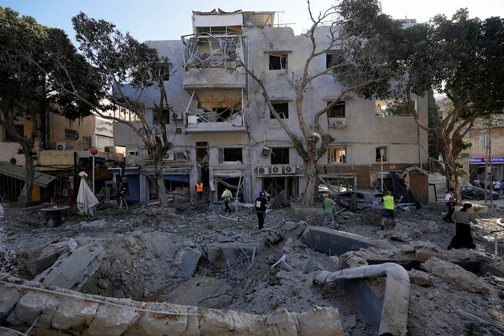 Israeli workers survey the site where a missile launched from Iran struck in Haifa on Sunday, June 22, 2025. (AP)