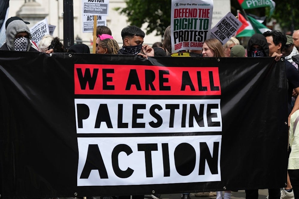 Demonstrators hold up a banner during a protest by Palestine Action group in London, Monday, June 23, 2025. (AP Photo/Frank Augstein)
