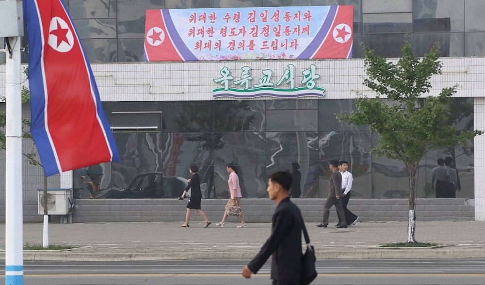 people walk in the Changjon Street on the 74th founding anniversary of the DPRK in Pyongyang, DPRK, on Friday, September 9th, 2022. (AP Photo/Jon Chol Jin) the poster says: Best respect to President Kim Il Sung and Chairman Kim Jong Il