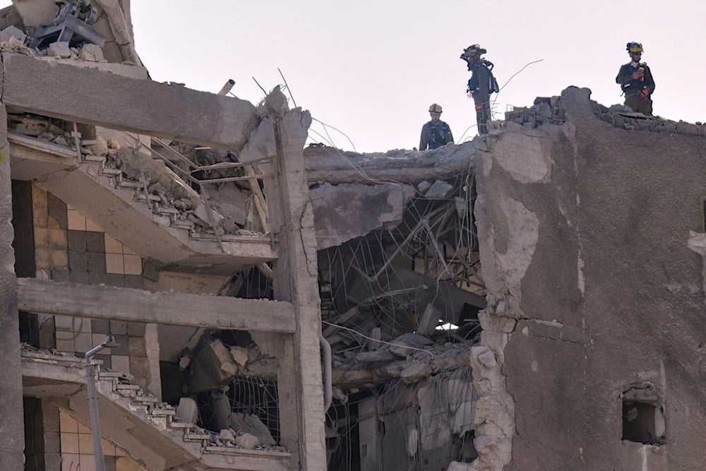 Israeli home front command units work in an unpopulated damaged building after it was hit by a missile fired from Iran, in Haifa, occupied Palestine, Friday, June 20, 2025 (AP)
