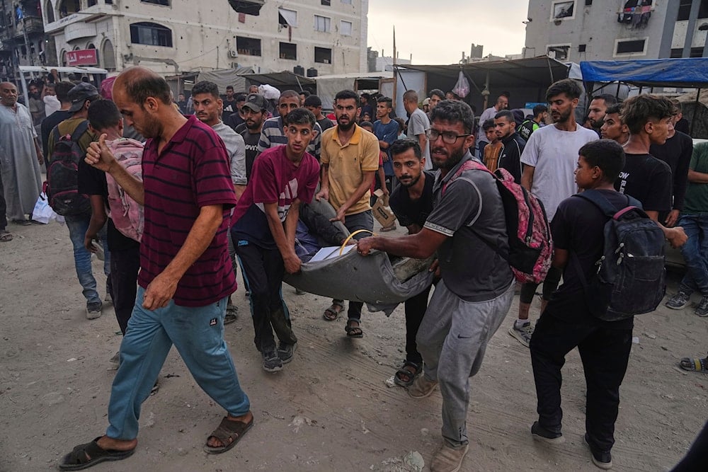 Palestinians carry an injured man after his foot was run over by a humanitarian aid truck amid a crowd scrambling for aid boxes in Gaza City, on June 22, 2025. (AP Photo/Jehad Alshrafi)
