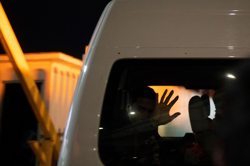 Migrants who were deported from the US to Mexico wave as they are transported to a shelter, as they cross El Chaparral pedestrian border bridge in Tijuana, Mexico, late Tuesday, Jan. 21, 2025. (AP)