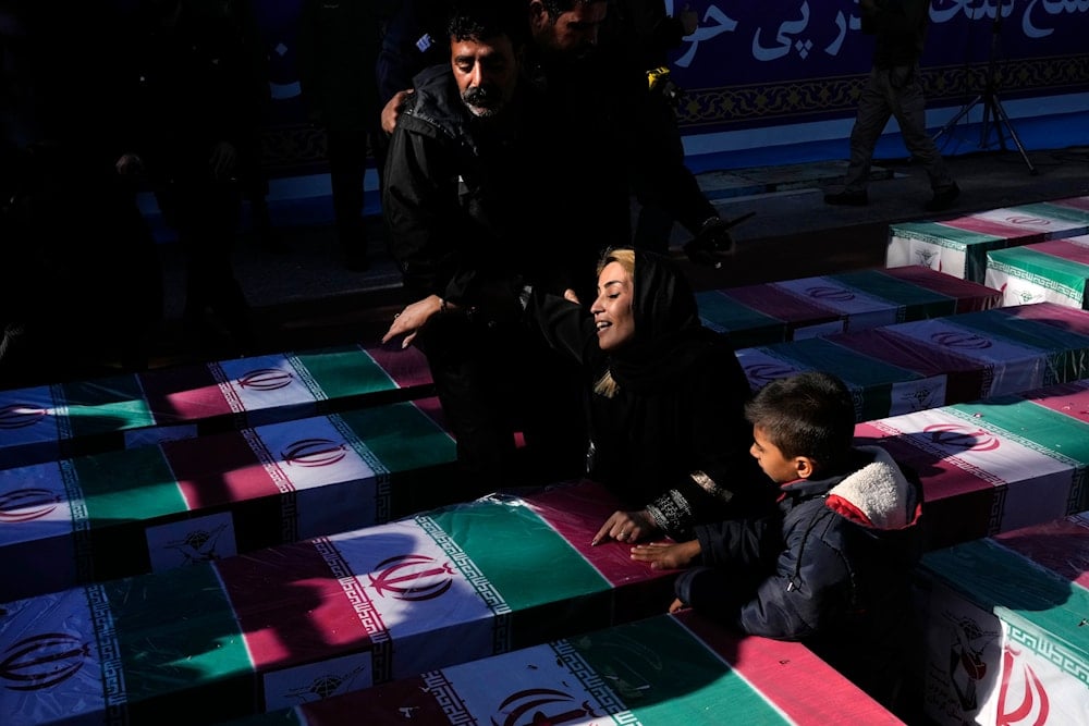 A woman mourns over the flag-draped coffin of her loved one who was killed in Wednesday's bomb explosion, during the victims funeral ceremony in the city of Kerman about 510 miles (820 kms) southeast of the capital Tehran, Iran, on Jan. 5, 2024. (AP)