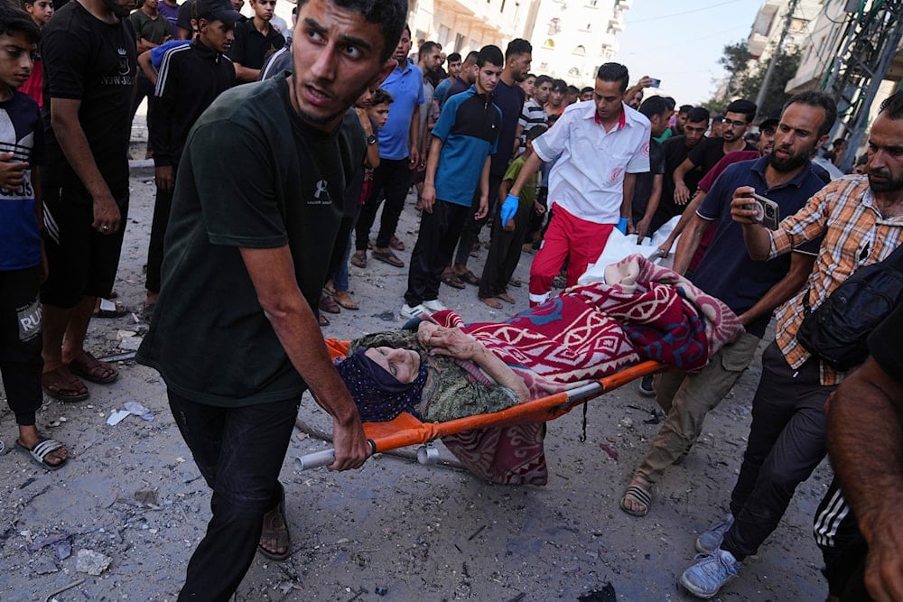 Palestinians evacuate a wounded elderly woman after an Israeli strike on a residential building in Gaza City, Friday, June 27, 2025 (AP)