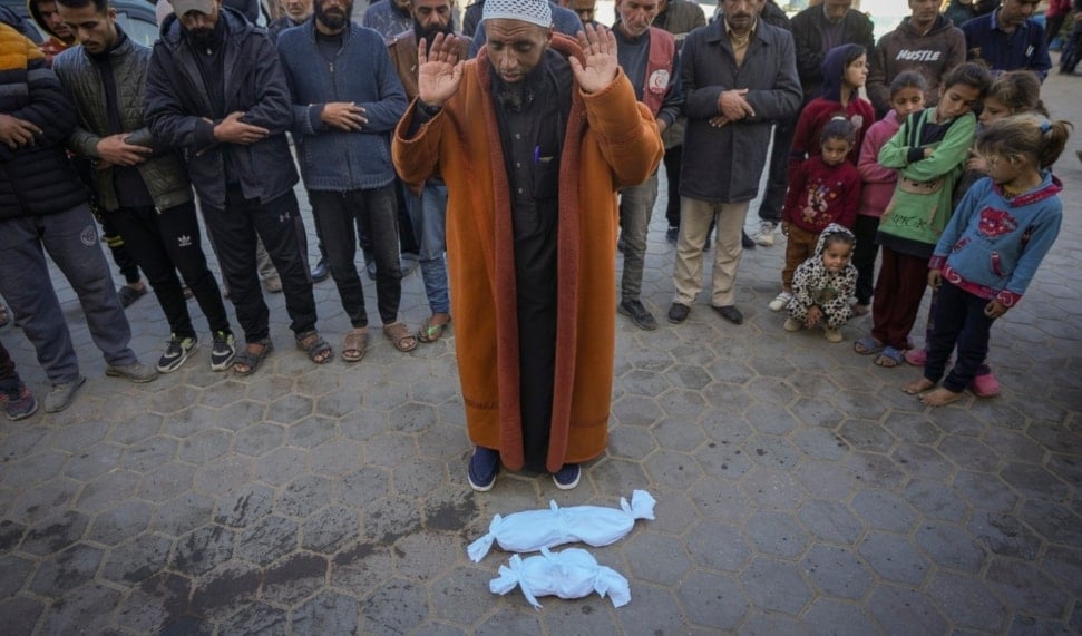 Imam Islam Abu Suaied prays over the bodies of two babies before their burial at the Al-Aqsa Martyrs Hospital in Deir al-Balah, central Gaza Strip, Sunday, Dec. 29, 2024. (AP)