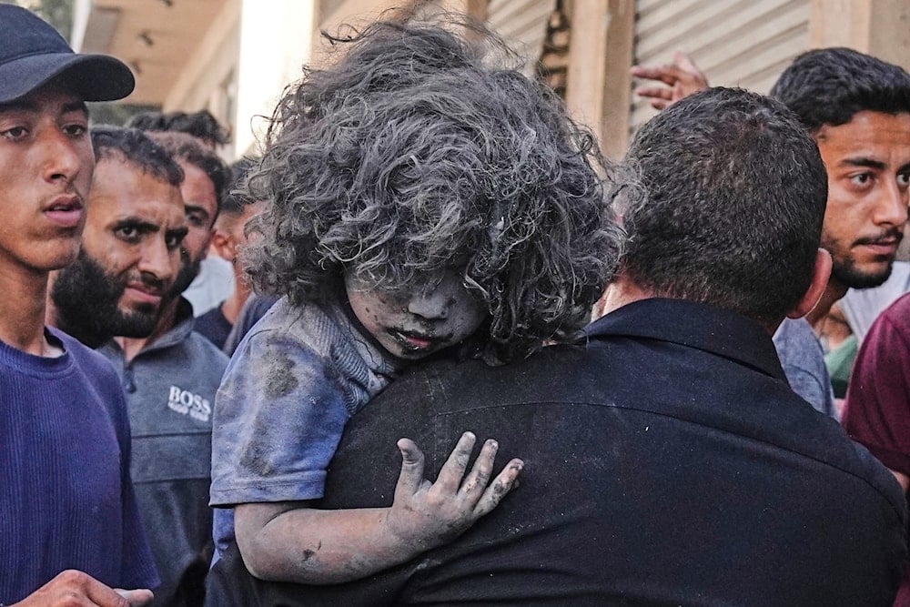 A Palestinian man carries a wounded child after an Israeli strike on a residential building in Gaza City, Friday, June 27, 2025. (AP)