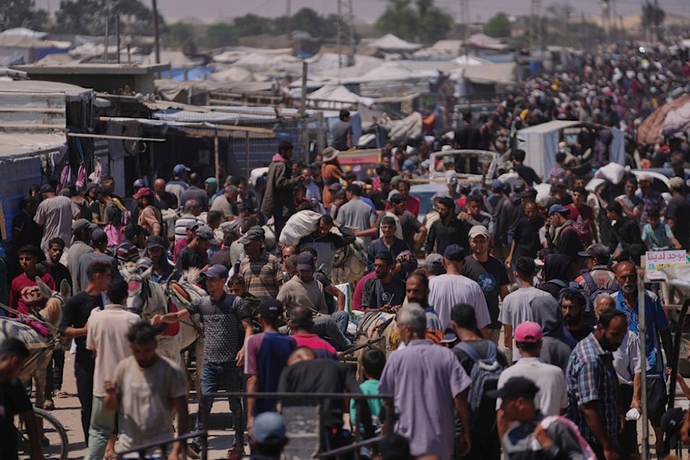 Palestinians carry bags containing food and humanitarian aid packages delivered by the Gaza Humanitarian Foundation, a US-backed organization, in Rafah, southern Gaza Strip, Wednesday, June 25, 2025 (AP)