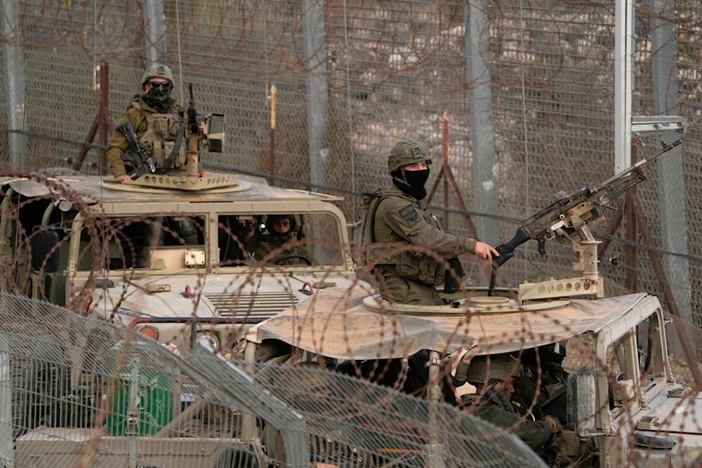 Israeli soldiers stand on armoured vehicles after crossing the security fence near the so-called Alpha Line between the occupied Golan Heights and Syria, in the town of Majdal Shams, December 21, 2024 (AP)