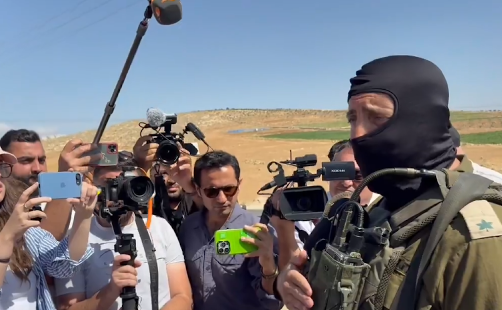 A screen grab from a video showing Masked Israeli occupation forces blocked a tour with dozens of international journalists saying they’re not allowed to enter Masafer Yatta and visit Basel Adra home. (X)