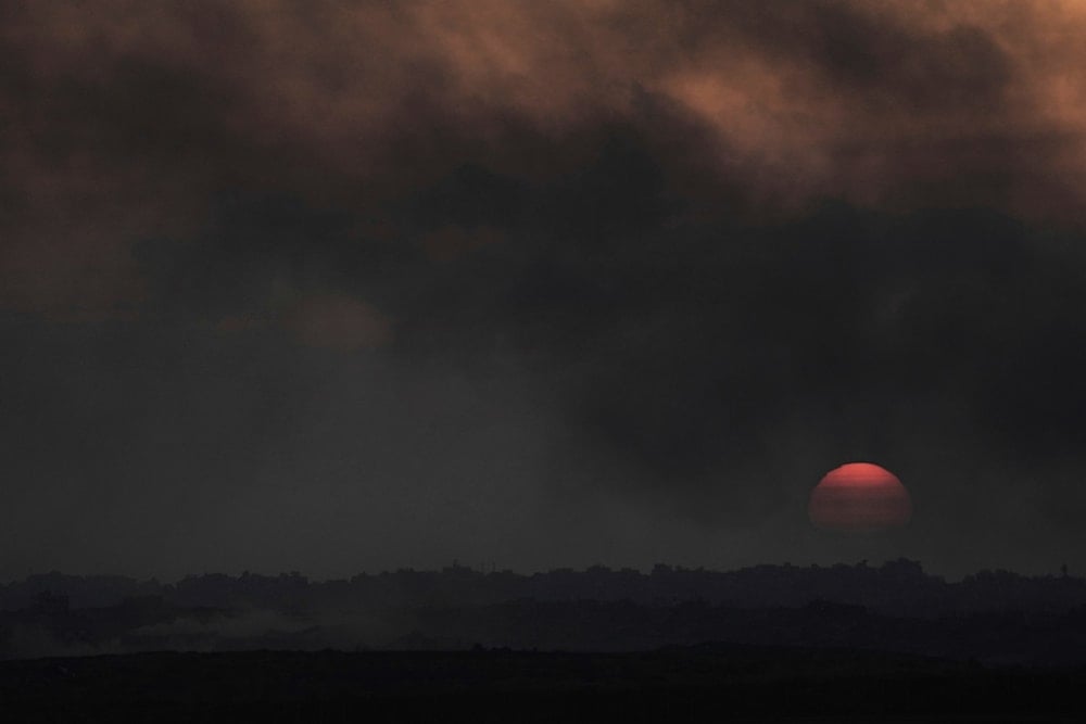 The sun sets as smoke from Israeli bombardment billows over buildings in the northern Gaza Strip, seen from southern occupied Palestine, Thursday, June 5, 2025 (AP)