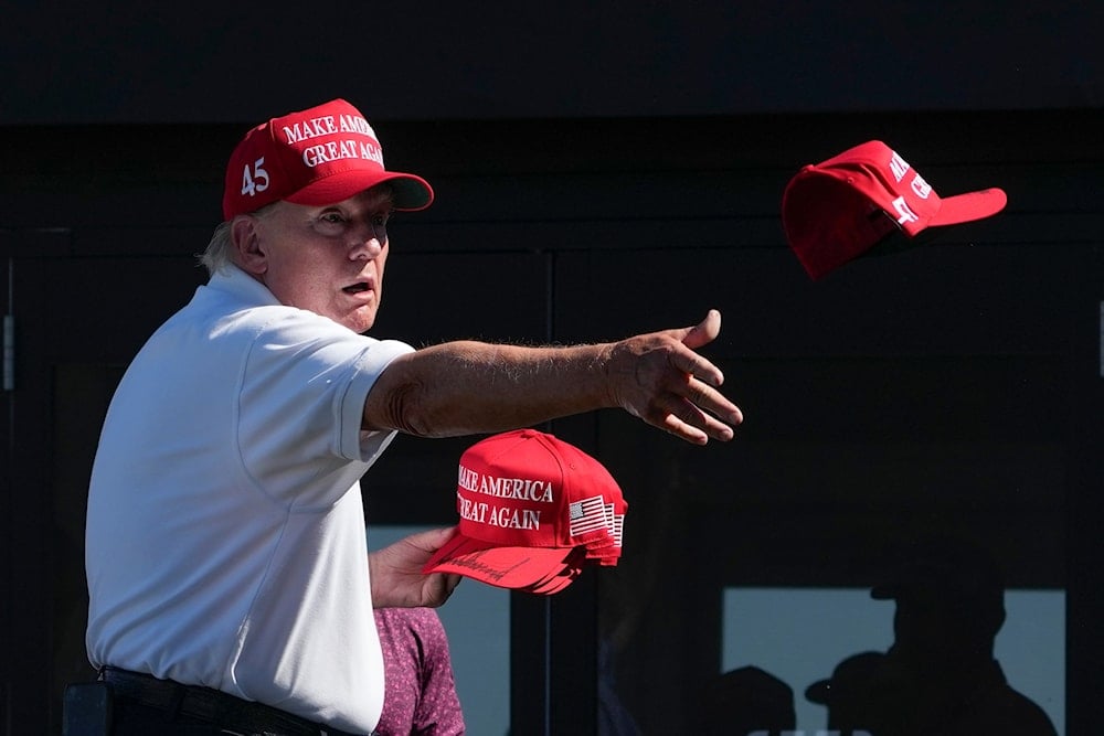 US President Donald Trump throws autographed hats to the crowd during the final round of the Bedminster Invitational LIV Golf tournament in Bedminster, N.J., Sunday, Aug. 13, 2023. (AP)
