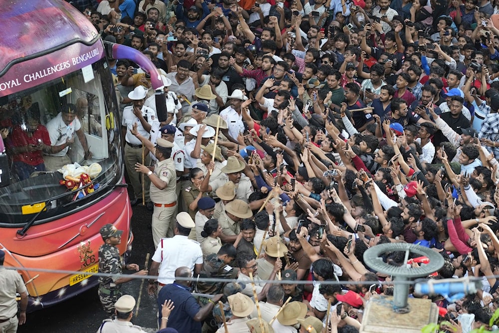 Fans cheer as the bus carrying Royal Challengers Bengaluru cricketers, winners of the Indian Premier League, arrive at the M. Chinnaswamy Stadium in Bengaluru, India, on June 4, 2025. (AP Photo/Aijaz Rahi)