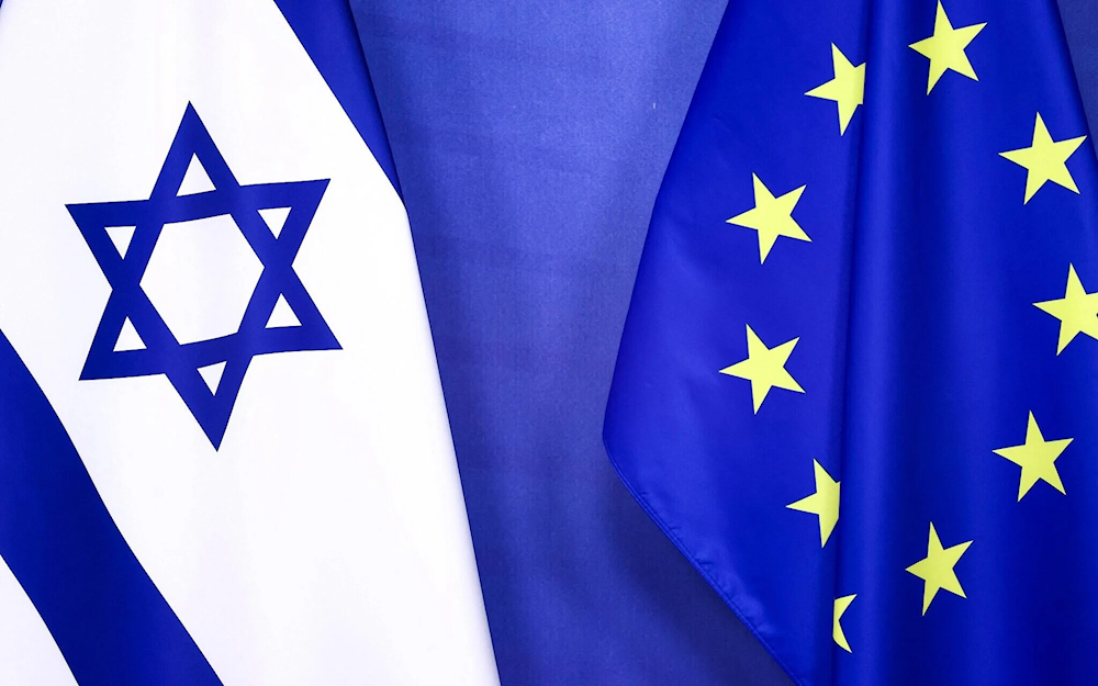 The Israeli occupation flag and the European Union flag are seen at EU headquarters in Brussels, on January 25, 2023 (Kenzo TRIBOUILLARD / AFP)