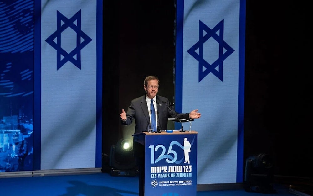 Israeli Occupation President Isaac Herzog delivers the keynote address on August 29, 2022, to mark the 125th anniversary of the First Zionist Congress at the Stadtcasino in Basel (Fabrice COFFRINI / AFP)